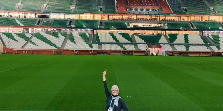 Paola Schietekat con uno de los estadios mundialistas de fondo