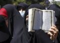 Mujeres con velo islámico y un Corán abierto